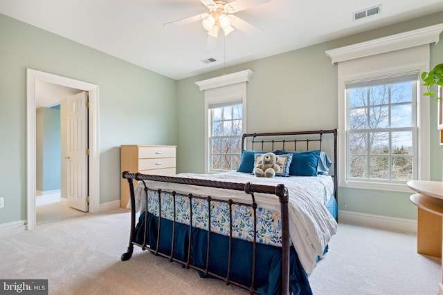 carpeted bedroom with visible vents, baseboards, and a ceiling fan