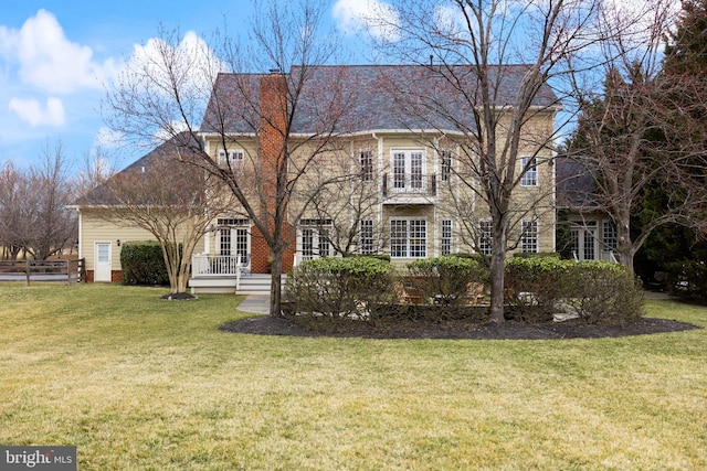 view of front of home featuring french doors, fence, a front yard, and roof with shingles