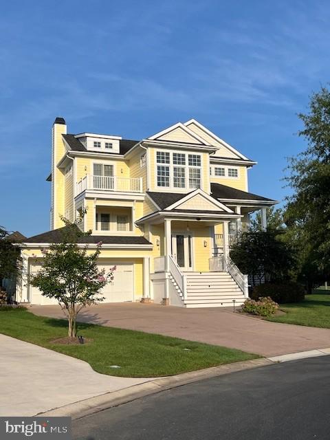 view of front of home featuring a garage, a balcony, and concrete driveway