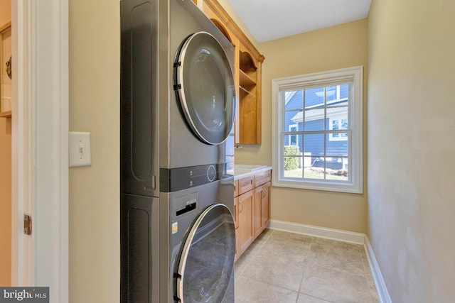 24537 Wave Maker Dr, Millsboro, DE 19966 - washroom with light tile patterned floors, cabinet space, baseboards, and stacked washing maching and dryer