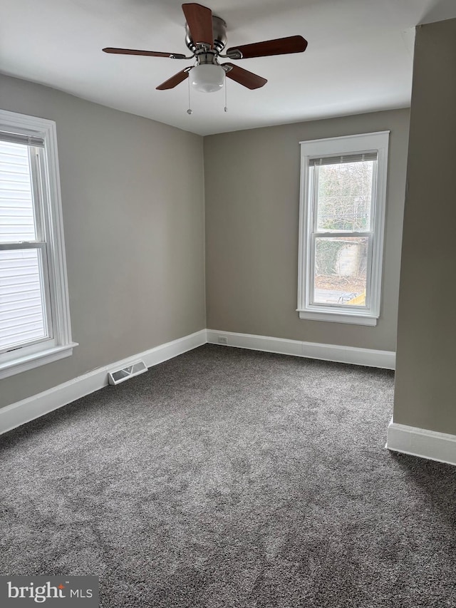 empty room featuring visible vents, baseboards, ceiling fan, and carpet flooring