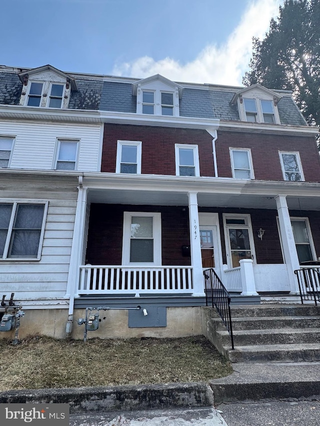 multi unit property featuring covered porch and mansard roof