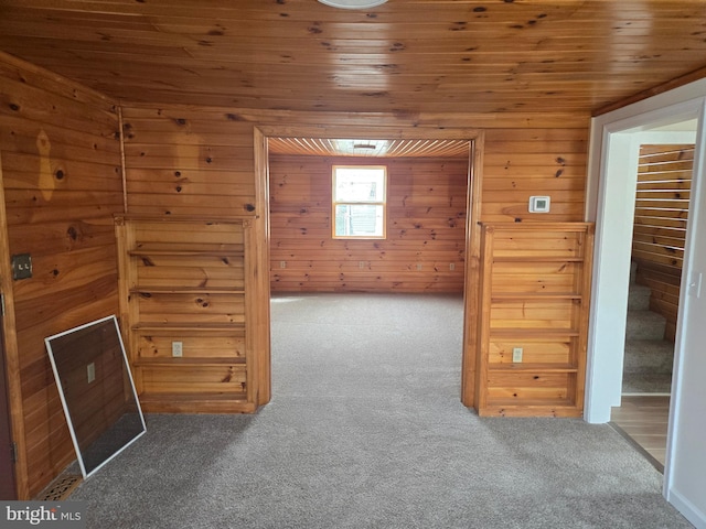 additional living space featuring carpet, wooden ceiling, and wooden walls