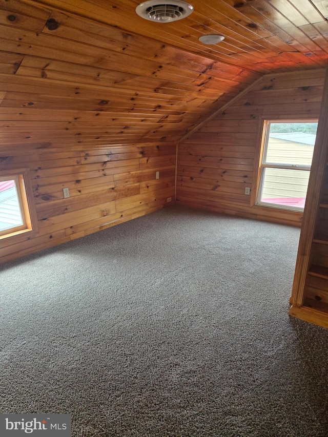 bonus room featuring wooden walls, visible vents, carpet floors, lofted ceiling, and wooden ceiling