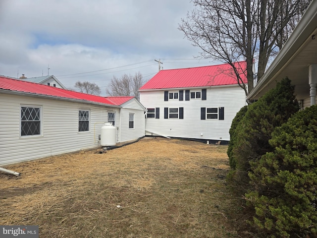 back of house featuring metal roof