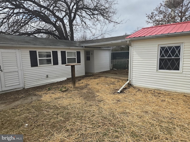 back of property featuring an attached carport and metal roof