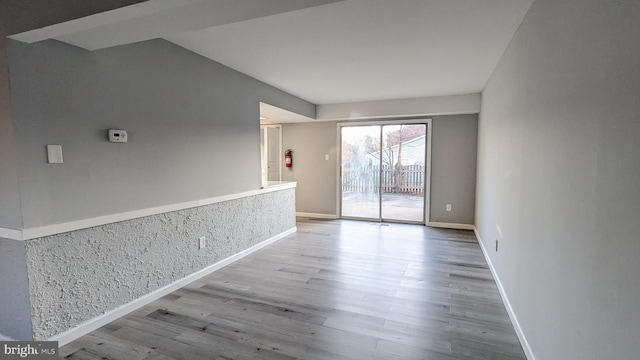 unfurnished room featuring baseboards and wood finished floors