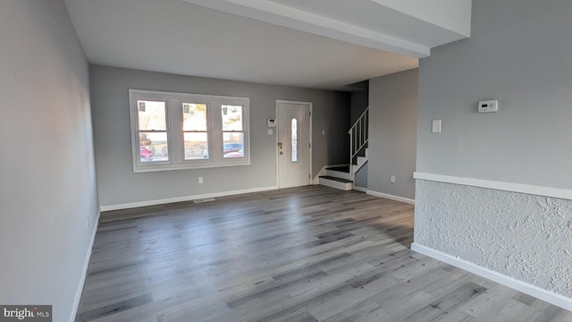 foyer entrance with visible vents, stairs, baseboards, and wood finished floors