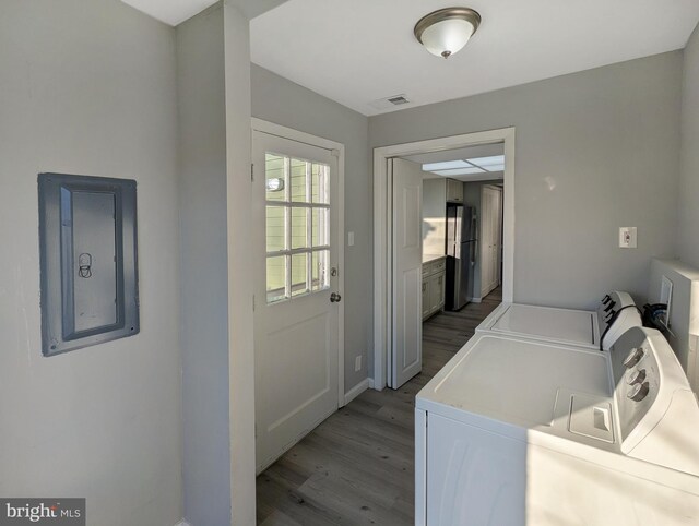 laundry room with light wood finished floors, visible vents, washing machine and dryer, electric panel, and laundry area