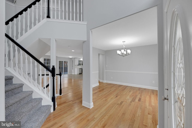 entryway with stairway, baseboards, and wood finished floors