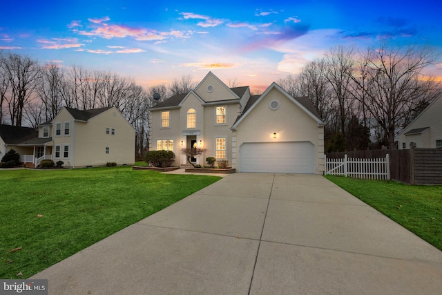 view of front of property featuring stucco siding, a lawn, driveway, fence, and an attached garage