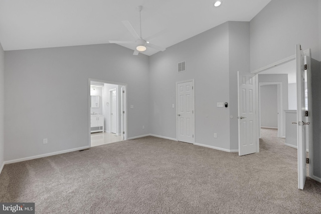 unfurnished bedroom with visible vents, baseboards, carpet flooring, ensuite bathroom, and high vaulted ceiling