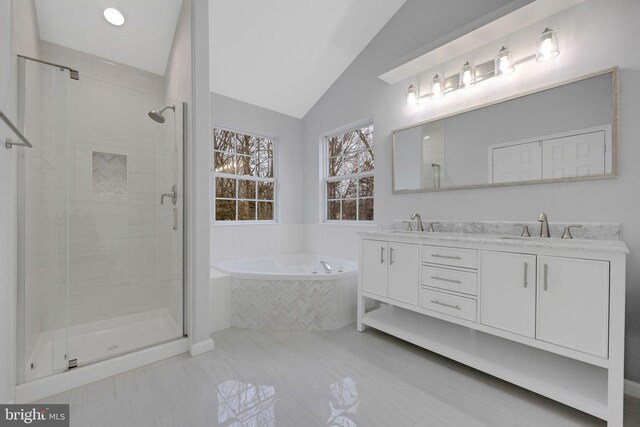 full bathroom featuring a shower stall, a bath, vaulted ceiling, and a sink