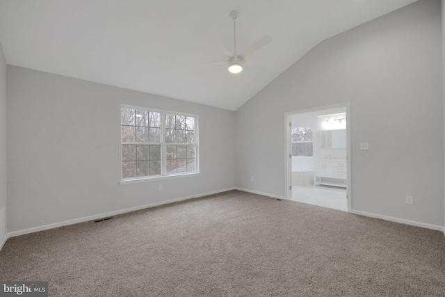 carpeted spare room with visible vents, baseboards, high vaulted ceiling, and ceiling fan