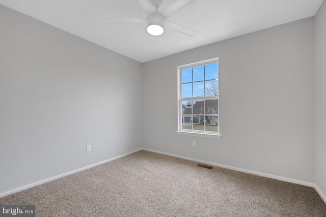 carpeted empty room featuring visible vents, baseboards, and a ceiling fan