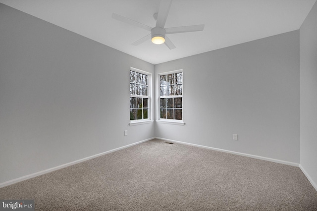 carpeted empty room featuring visible vents, baseboards, and ceiling fan