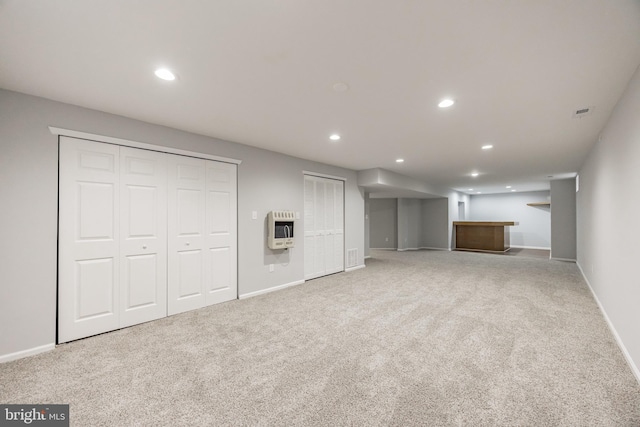 unfurnished living room with recessed lighting, heating unit, and carpet floors