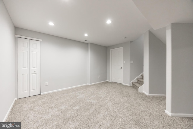 carpeted spare room featuring recessed lighting, stairs, and baseboards