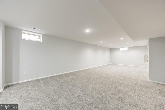 below grade area featuring carpet flooring, recessed lighting, visible vents, and baseboards