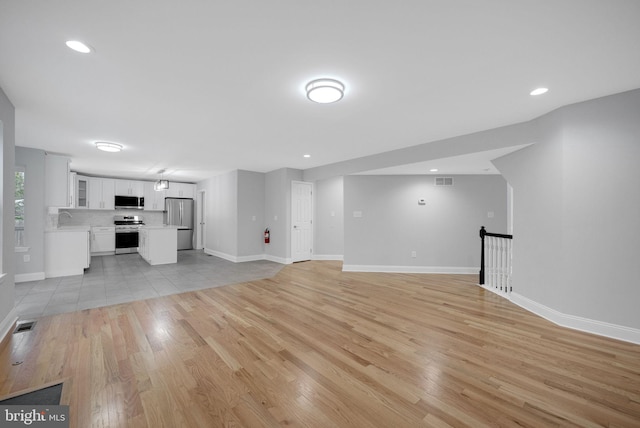 unfurnished living room featuring recessed lighting, visible vents, baseboards, and light wood finished floors