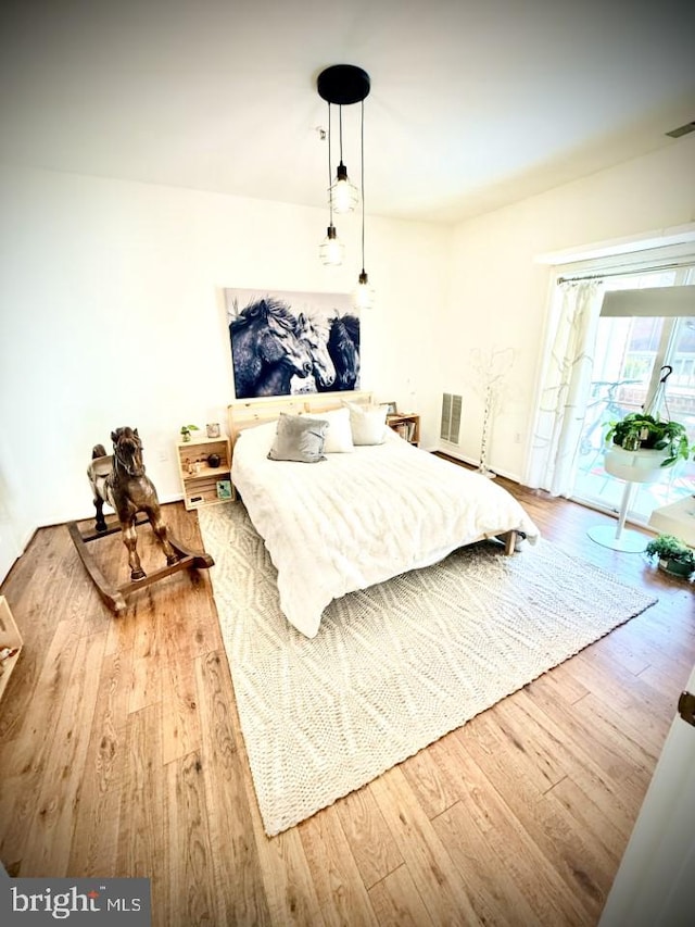 bedroom featuring visible vents, wood finished floors, and access to exterior