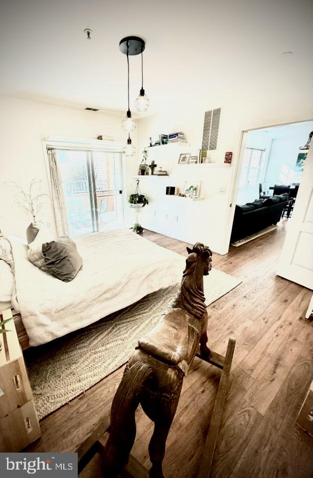 bedroom featuring wood finished floors and visible vents