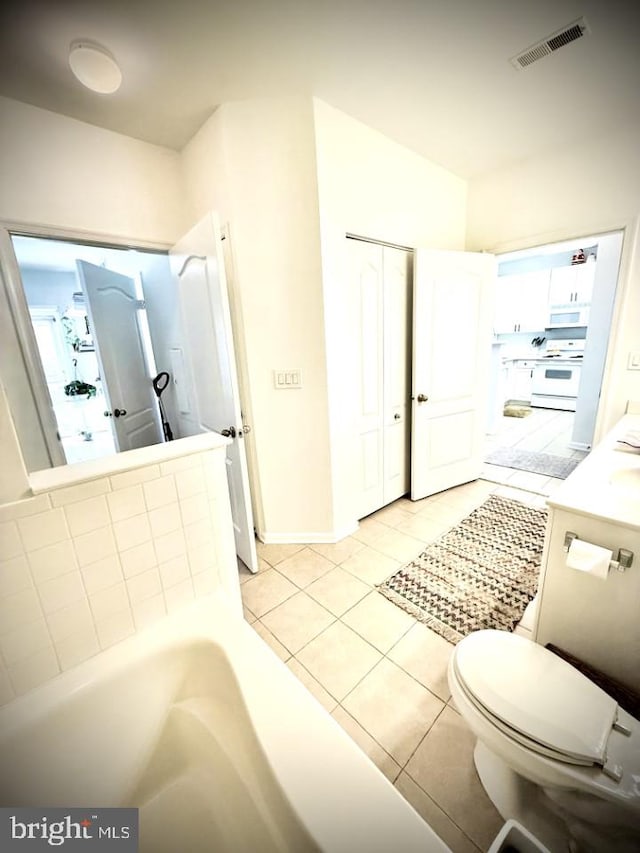 full bath with vanity, a bath, visible vents, tile patterned flooring, and toilet