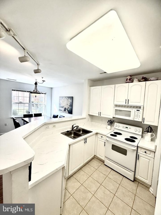 kitchen featuring white appliances, white cabinetry, a peninsula, and a sink