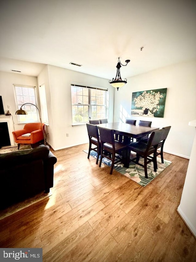 dining space featuring wood finished floors, visible vents, a wealth of natural light, and baseboards