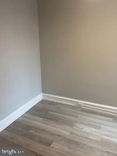 empty room with baseboards and wood finished floors