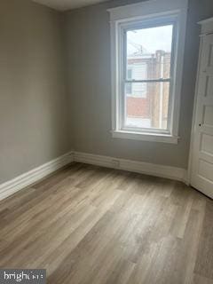 spare room featuring baseboards and wood finished floors