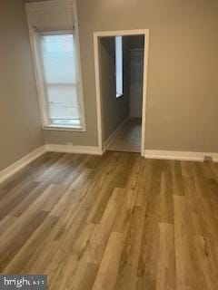 empty room with baseboards and wood finished floors