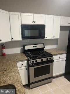 kitchen with light stone counters, black appliances, and white cabinetry