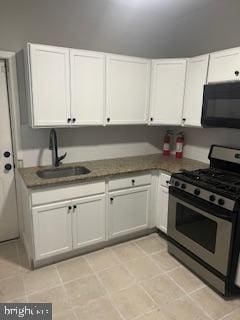 kitchen featuring a sink, dark countertops, stainless steel range with gas cooktop, white cabinets, and black microwave