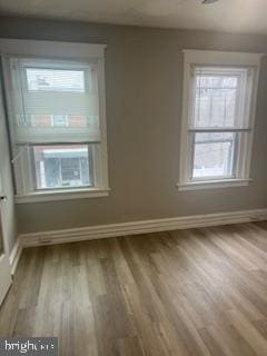 unfurnished room featuring baseboards and wood finished floors