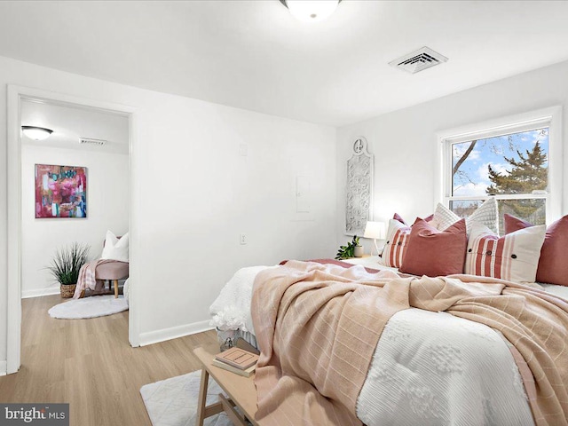 bedroom featuring visible vents, baseboards, and light wood-style floors