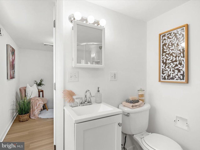 bathroom featuring vanity, toilet, wood finished floors, and visible vents