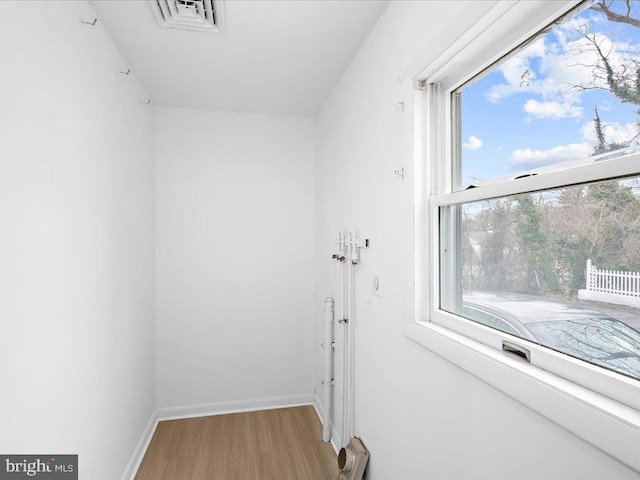 interior space with visible vents, baseboards, and wood finished floors