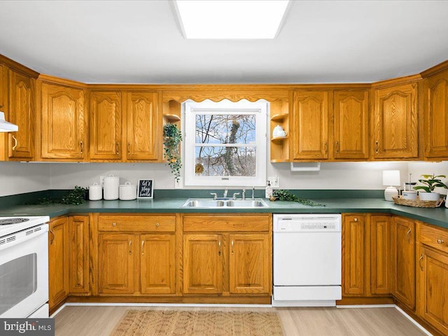 kitchen with white appliances, brown cabinets, and a sink