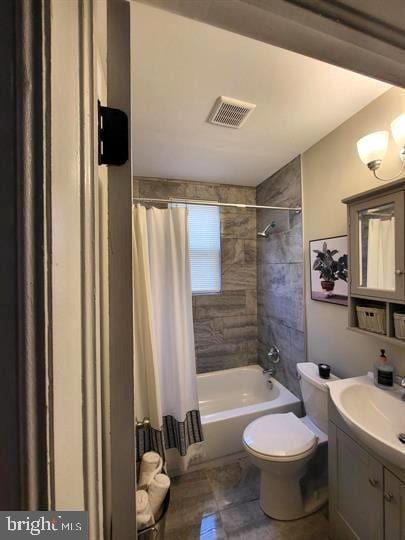 full bath featuring visible vents, toilet, vanity, and shower / bath combo