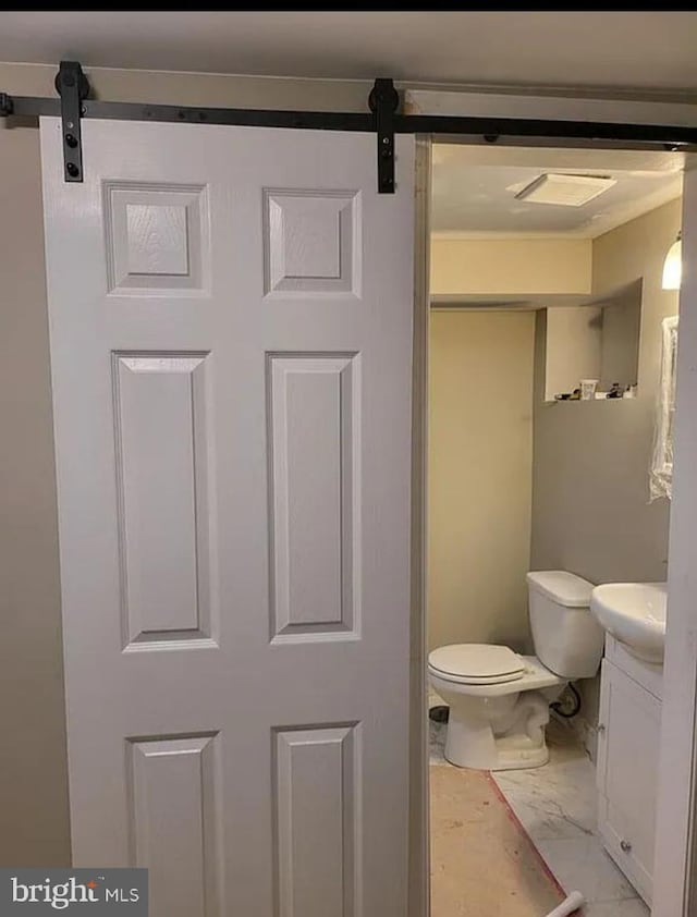 bathroom with marble finish floor, toilet, and vanity