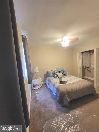 carpeted bedroom with baseboards and ceiling fan