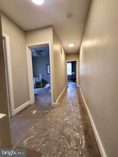 hall with baseboards and visible vents