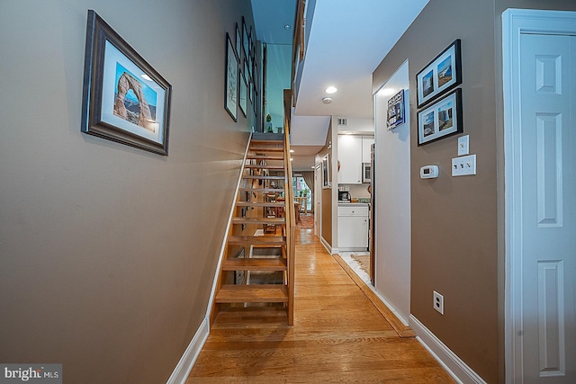 stairs with wood finished floors and baseboards