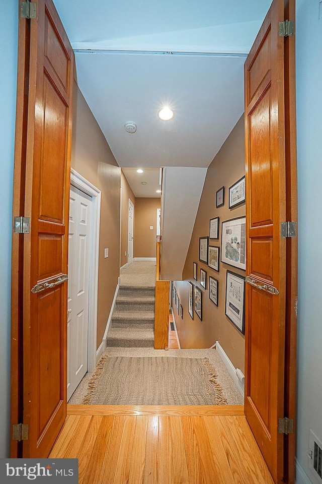 staircase featuring visible vents, recessed lighting, baseboards, and wood finished floors