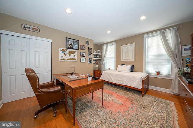 bedroom featuring light wood-style flooring, recessed lighting, a closet, and baseboards