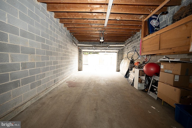 garage with concrete block wall and a garage door opener