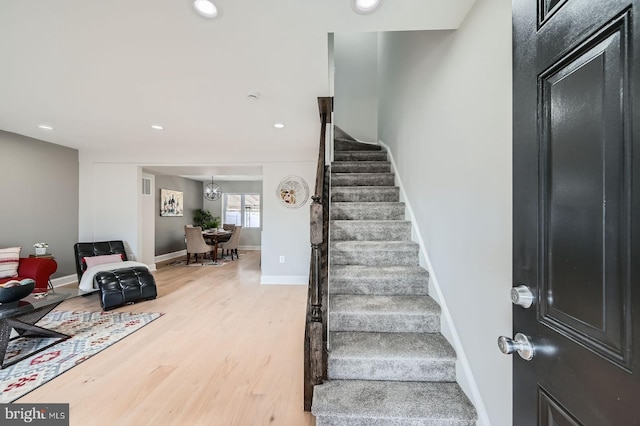 stairs with recessed lighting, wood finished floors, and baseboards