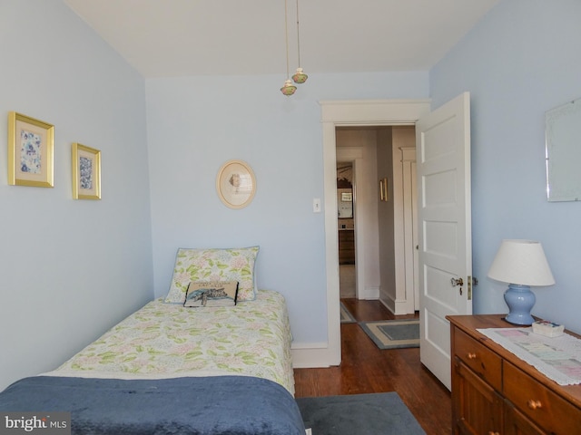 bedroom featuring baseboards and dark wood-style flooring