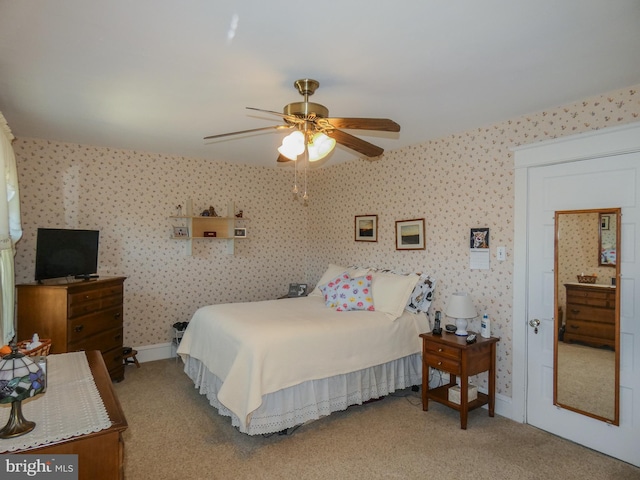 bedroom featuring baseboards, light colored carpet, a ceiling fan, and wallpapered walls